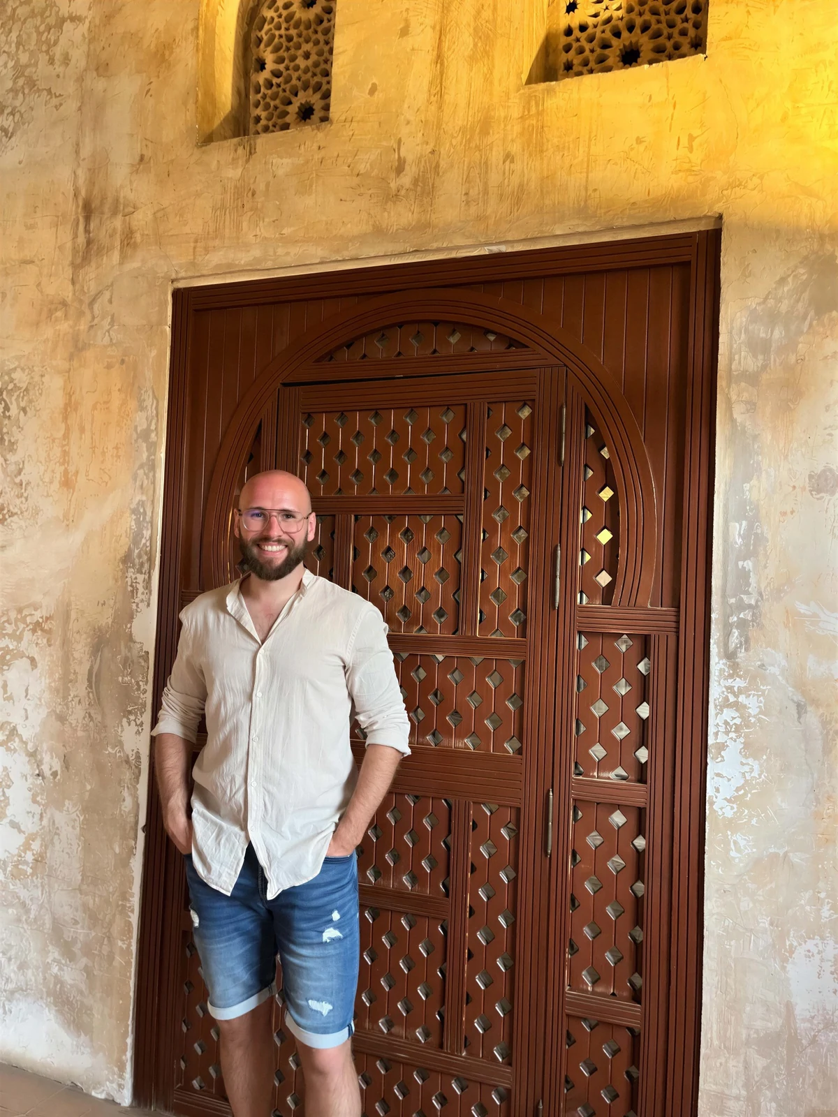 Alexandre devant une porte traditionnelle lors d’un voyage